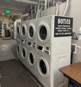 right view of Step Denver's eight white commercial laundry machines commercially installed by Dryer Vent Techs